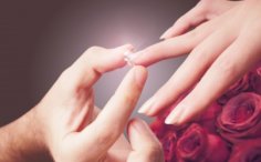 男性が女性の薬指に婚約指輪をはめている手元